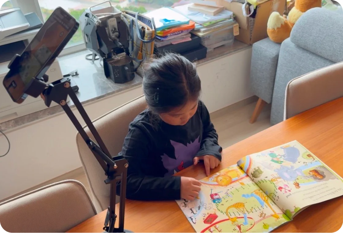 Child reading with a Lestori phone mount over a picture book